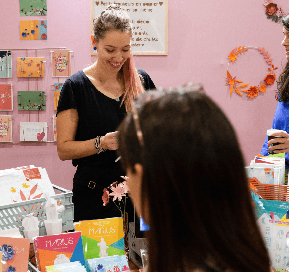 Jeune femme souriante sur un stand lors du salon DIY Créations & savoir-faire