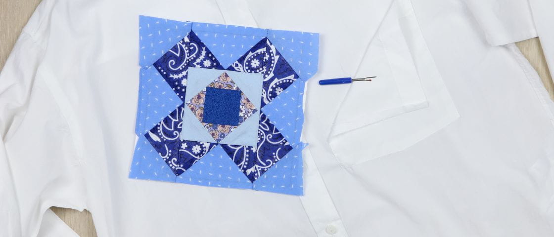 Coudre une pièce de patchwork sur une chemise blanche