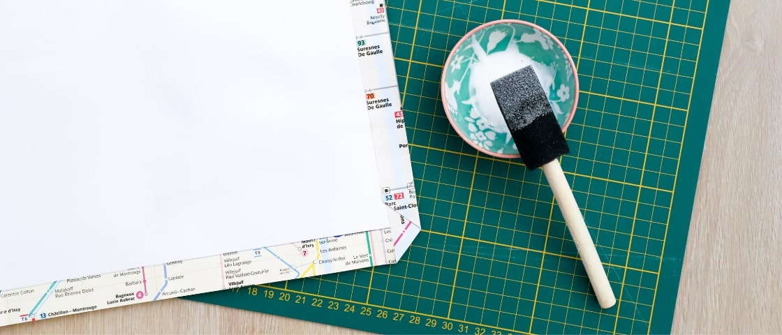 Matériels pour carnet de voyage DIY fait main : plan de métro, pot de colle et pinceau